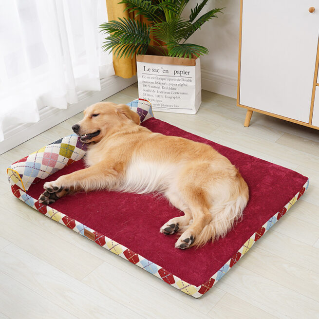 Cama esquinera de diseño con cuadros de colores y terciopelo rojo para perros con un perro encima